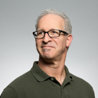 Professional portrait of a middle-aged man with glasses, smiling slightly, showcasing the team at Elite Aeolabs, emphasizing the company's focus on innovative software development.